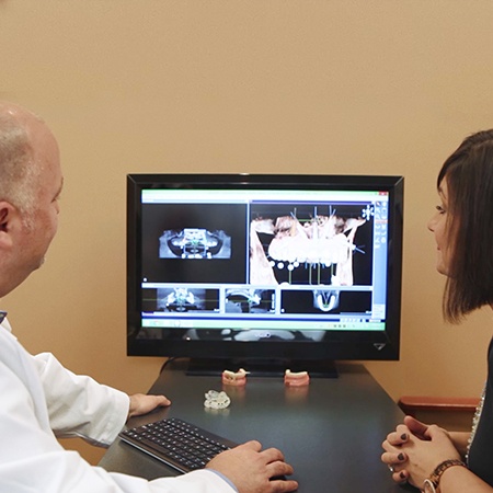 Periodontist and patient reviewing digital images on chairside computer
