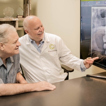 Periodontist and patient reviewing digital images on chairside computer