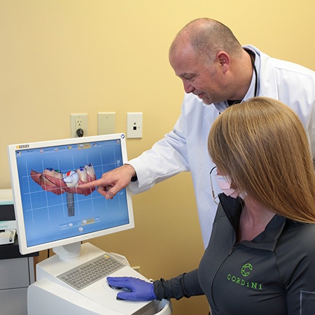 Periodontist and team member looking at digital impressions on chairside computer