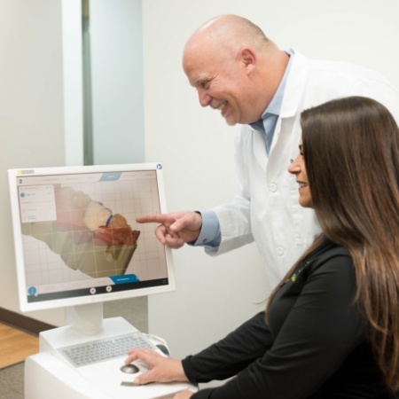 Periodontist and team member looking at digital impressions on chairside computer