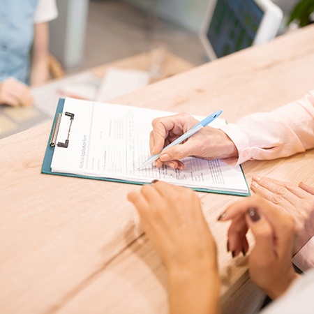 Peridontal patient filling out dental insurance forms