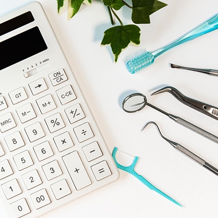 Calculator resting next to series of dental tools