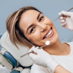 Dentist showing patient model of dental implant in Louisville, KY