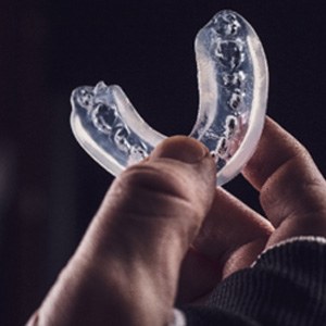 Closeup of patient holding clear mouthguard