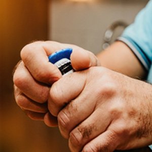 Closeup of patient using bottle cap opener