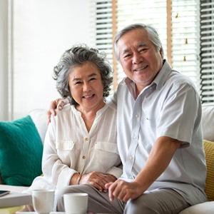 Smiling couple with dental implants in Louisville