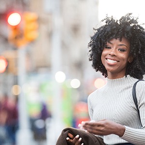 Woman in white sweater walking on busy city street