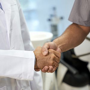 Close-up of periodontist and patient shaking hands