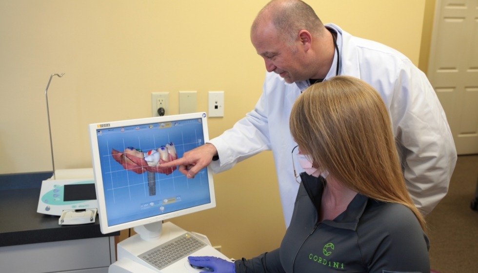 Doctor cordini and team member reviewing digital impressions on chairside computer