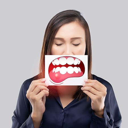a patient holding up a picture of teeth and gums