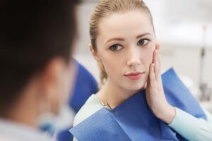 Woman with toothache talking to dentist