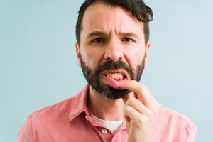 Concerned man pulling down his lip to show gums